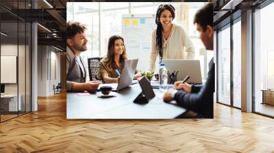 Business team meeting in the office. Woman presenting project to colleagues Wall mural