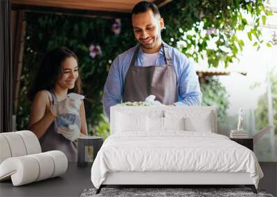 Father and daughter watering potted plants at home Wall mural