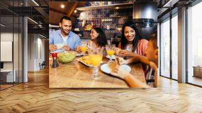 Latin family having dinner at home Wall mural