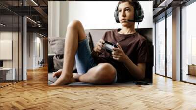 Teenager playing video games at home Wall mural