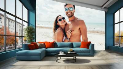 Young couple having fun on tropical beach Wall mural