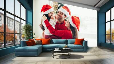 Young family celebrating Christmas at home.Happy young family enjoying their holiday time together. Wall mural