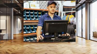 Young latin man working in hardware store Wall mural