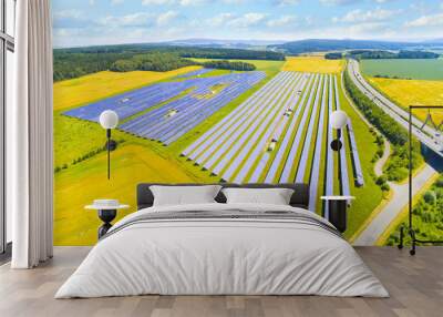 Camera flight over a solar power plant in agricultural landscape. Industrial background on renewable resources theme. Industry of power and fuel generation in European Union.  Wall mural