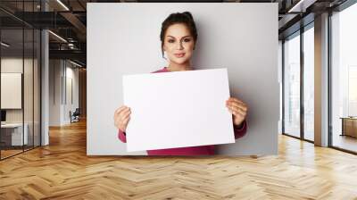 Beautiful young women with banner sign with white blank empty paper billboard with copy space for text over gray background Wall mural