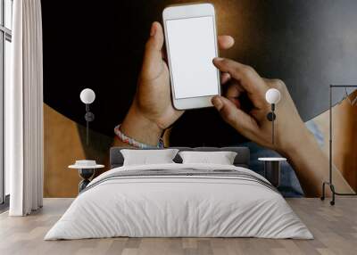 Closeup view of male hands touching mobile phone.African man using smartphone while sitting at the wooden table.Empty white blank copy space screen for your information.Mockup. Wall mural