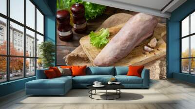 Beef tongue on a wooden Board on a brown wooden table. Raw beef tongue on the kitchen table. Rustic style Wall mural