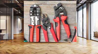 Tools of an electrician-fitter or Builder on a gray wooden table. Construction tools: screwdrivers, crimps, knife and tape measure on the table. Top view with space for text. Banner Wall mural