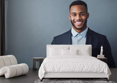 A confident young businessman in a suit, smiling, symbolizes success and innovation against a grey background. Wall mural