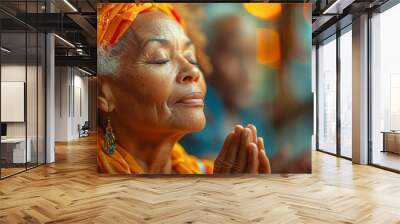 An elderly black woman expresses gratitude during Thanksgiving by folding her hands in prayer Wall mural