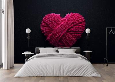 heart shaped symbol made of pink yarn on dark background, emphasizing awareness and care. texture and color create warm, heartfelt expression Wall mural