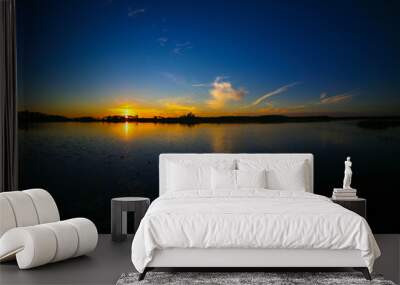 Reflection of orange and blue sky over the lake during sunset in Florida.  Wall mural