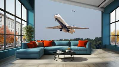 Two commercial airliners in flight in clear blue sky Wall mural