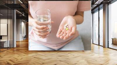 antibiotic meds, hand holding medical pill capsule, take medicine for flu, influenza, painkiller, vitamin for treatment, sick female taking with drinking with water at home, pharmacy and healthcare Wall mural