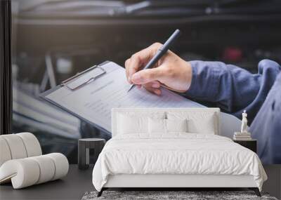 Auto check, car service shop concept. Automobile repairman writing job checklist on clipboard, mechanic checking engine to estimate repair machine, inspecting maintenance by engineer at vehicle garage Wall mural