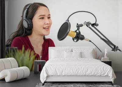 Beautiful asian young woman radio host working in headphones, microphone while talk, conversation and recording podcast, live on social media.Technology of on-air online in broadcasting at studio. Wall mural