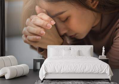 Believe faith charity, calm asian young woman show gratitude, folded hands in prayer feel grateful, meditating with her eyes closed, praying to request God for help. Religious, forgiveness concept. Wall mural