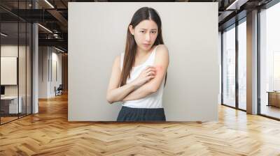 Dermatology asian young woman, girl allergy, allergic reaction from atopic, insect bites on her arm, hand in scratching itchy, itch red spot or rash of skin. Healthcare, treatment of beauty. Wall mural