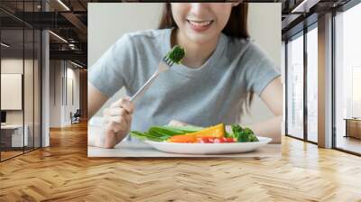 Diet, Dieting asian young woman or girl use fork at broccoli on mix vegetables, green salad bowl, eat  food is low fat good health. Nutritionist female, Weight loss for healthy person. Wall mural