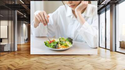 Diet in bored face, unhappy beautiful asian young woman, girl on dieting, holding fork at tomato on salad plate, dislike or tired with eat fresh vegetables. Nutrition of clean, healthy food good taste Wall mural