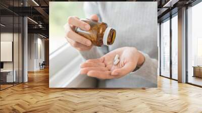 Dietary supplement or sick, asian young woman, girl hold pills, drugs medical tablet on hand pouring capsules from medication bottle, take vitamin for treatment for skin, hair at home, healthcare. Wall mural