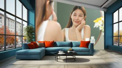 Freshness, nice healthy. Beautiful asian young woman, girl looking on reflection in mirror, hand touching face with makeup cosmetic, skin care routine at home. Happy smile female with natural beauty. Wall mural