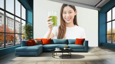 Green detox juice concept, Beautiful asian young woman hand holding vegetable smoothie glass for diet on background. Happy girl drinking healthy meal food for weight loss. Lifestyle, vegan nutrition. Wall mural