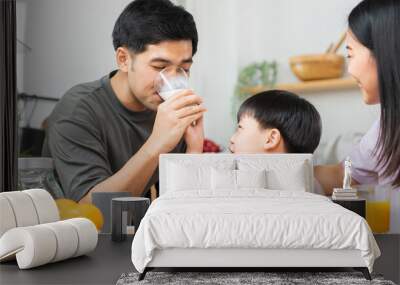 Happy refreshment family breakfast in morning, asian young parent father, mother and little cute boy, child having meal in kitchen eating together at home. Cheerful, enjoy cooking people. Wall mural