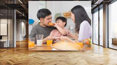 Happy refreshment family breakfast in morning, asian young parent father, mother and little cute boy, child having meal in kitchen eating together at home. Cheerful, enjoy cooking people. Wall mural