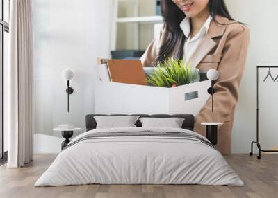 Happy smiling asian young business woman office worker celebrating resignation, holding belongings into cardboard box leaving office after quitting job, change position, leaves the company, leave job Wall mural