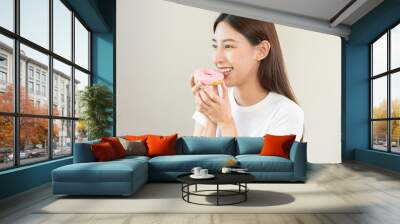 Portrait of attractive beautiful girl, pretty asian young teenage woman holding pink donut, doughnut, emotion enjoy sweet. Dieting, diet for loss weight to slim. Isolated white background, copy space. Wall mural