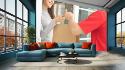 Postman, service shopping online asian young woman, girl hand received order, delivery man, male holding, carrying paper bag send to customer house. Deliver, courier bring product to doorway at home. Wall mural