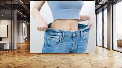 Shape slender, thin waist, attractive slim asian young woman, hand show shape her weight loss, wearing in big, large or oversize jeans, excess lose by diet and exercise. People body fit healthy. Wall mural