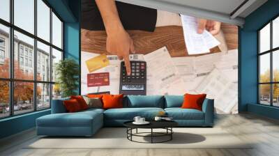 Top view financial owe asian young man sitting suffer, stressed and confused by calculate expense from invoice, credit card bill no money to pay mortgage or loan. Debt, bankrupt or bankrupt people. Wall mural