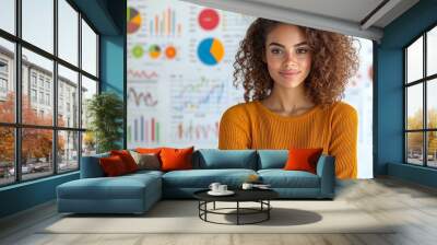 Confident Woman with Curly Hair Smiling in Front of Business Charts and Graphs Wall mural