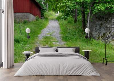 Gravel and grass path leading past a red cabin, as a nature and vacation background
 Wall mural