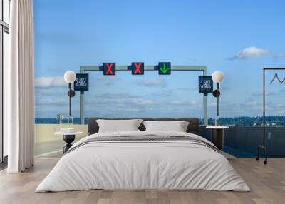 Overhead electronic highway sign, 2 left lanes closed, red x and green arrow, on a sunny blue sky day
 Wall mural