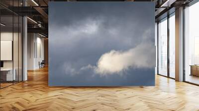 Stormy gray skies with one cloud highlighted white by the sun, as a nature background
 Wall mural