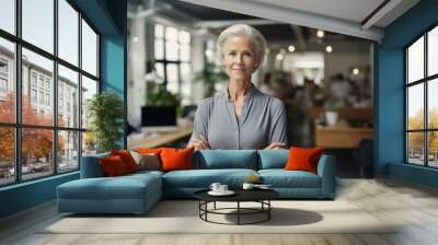 Portrait of confident mature businesswoman standing with arms crossed in office Wall mural