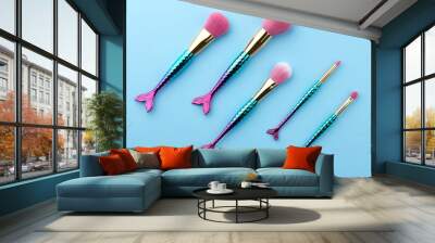 Fish shape glossy make up brushes close up on blue background Wall mural