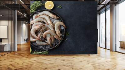 Fresh tiger prawns in a plate with ice on black textured background, top view Wall mural