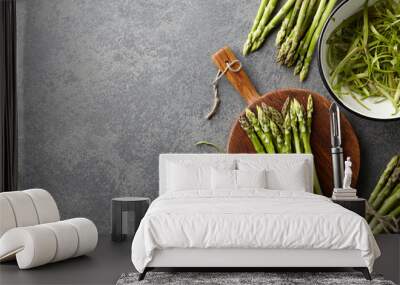 Peeling and cooking fresh raw asparagus on stone kitchen countertop, top view Wall mural