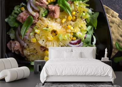 bowl with salad with tuna, pineapple and corn on a dark table Wall mural