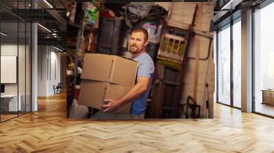 Hes on top of the moving game. Portrait of a young man packing boxes. Wall mural