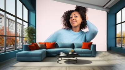 African woman with curly hair looking to camera, smiling. Beautiful model girl on white studio background. Wall mural