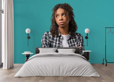 Bored upset african woman sighs, rolling eyes on blue. Teenager in displeasure Wall mural