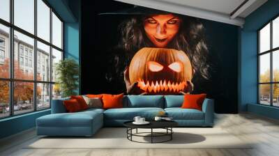 Mysterious black witch with pumpkin as head of jack-o-lantern on dark backdrop. Scary symbol of Halloween, masquerade costume, party decoration. Magic, classic hag Wall mural