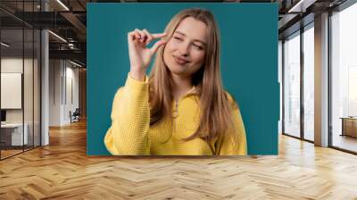 Young woman showing small invisible abstract subject, tiny object sizes Wall mural