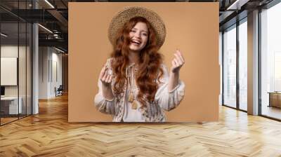 Young woman with money gesture on beige studio background. Smart lady smiling Wall mural