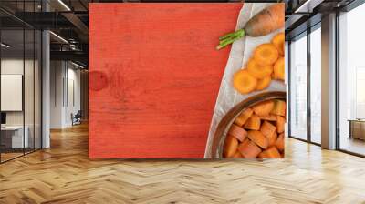 freshly cut carrot slices in plate on red wooden table, cooking vegetarian salad for healthy eating Wall mural